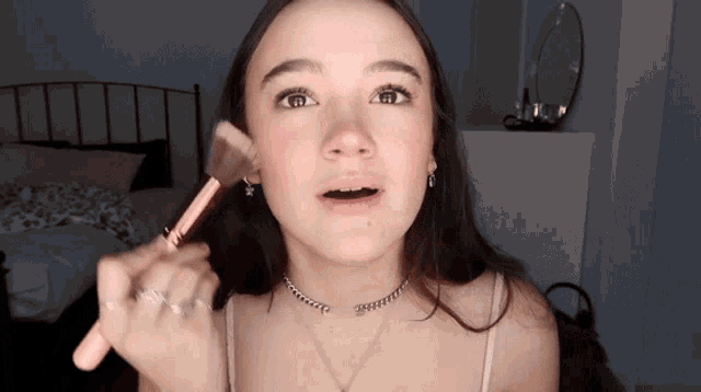 a woman wearing a choker and a ring is holding a brush