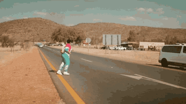 a person crossing a road with a white van in the background