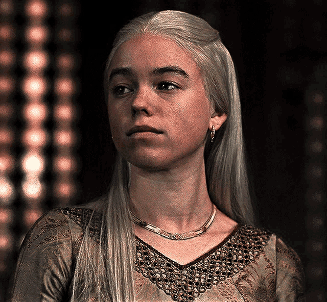 a woman with long blonde hair wearing a necklace
