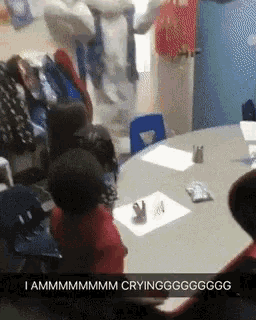 a group of children sitting around a table with a caption that says i ammmmmm crying g
