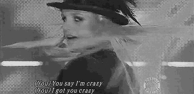 a black and white photo of a woman wearing a hat with the words `` you say i 'm crazy you i got you crazy ''