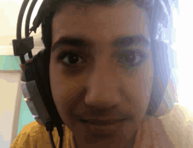 a close up of a person wearing headphones looking at the camera