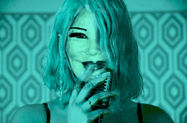 a woman with blue hair is holding a glass of wine