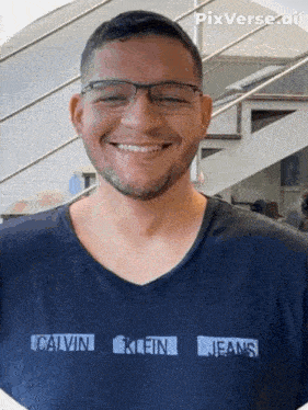 a smiling man wearing glasses and a calvin klein jeans shirt
