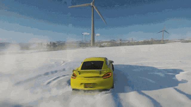 a yellow car is driving through the snow on a sunny day