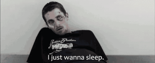 a man wearing a justice brothers t-shirt is laying on a bed .