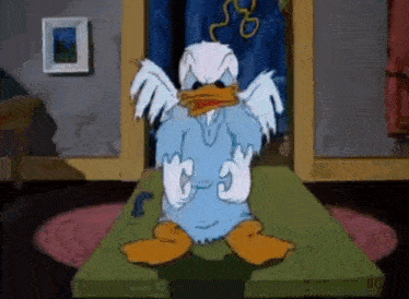 a cartoon duck is sitting on a table with its wings spread .