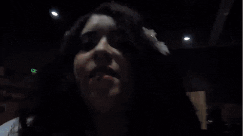 a woman with a flower in her hair looks at the camera