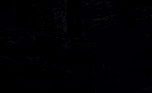 a close up of a guitar in a dark room with a black background .