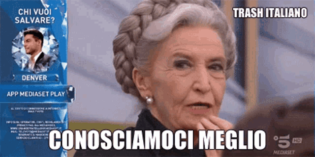 an older woman with gray hair is looking at a screen that says app mediaset play
