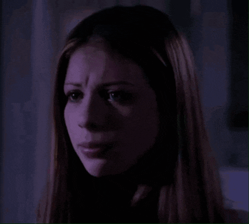 a close up of a woman 's face with purple light behind her