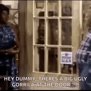 a man and a woman are standing in front of a door and talking to each other .