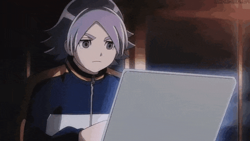 a boy is sitting in a chair looking at a laptop .