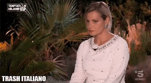 a woman in a white sweater is sitting in front of a palm tree with the words trash italiano on the bottom