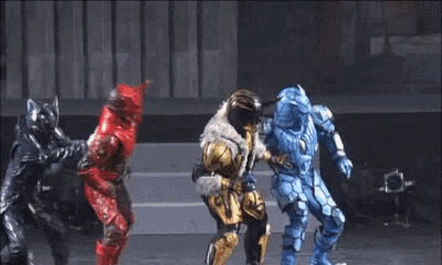 a group of robots are dancing on a stage in a room .