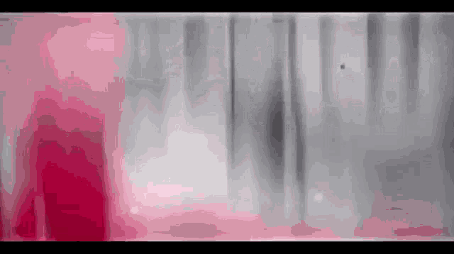 a close up of a pink and gray background with a blurred image of a person .