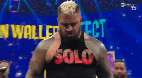 a man in a solo tank top stands on a stage