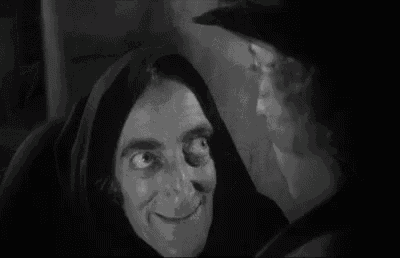 a black and white photo of a man and a woman looking at each other .