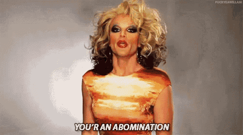 a drag queen is saying you 're an abomination while wearing a red dress .