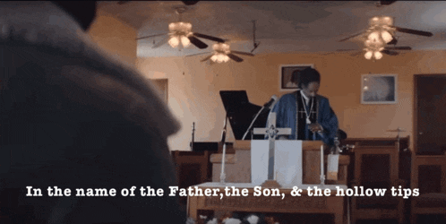 a man stands at a podium with the words in the name of the father the son and the hollow tips above him