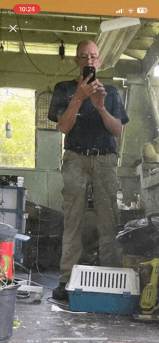 a man is taking a picture of himself in a dirty room with the time of 10:24