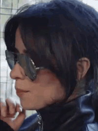 a woman wearing sunglasses and a black leather jacket
