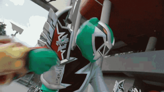 a person in a green and white costume with the letter a on the chest