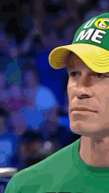 a man wearing a green shirt and a yellow hat that says ucs me on it
