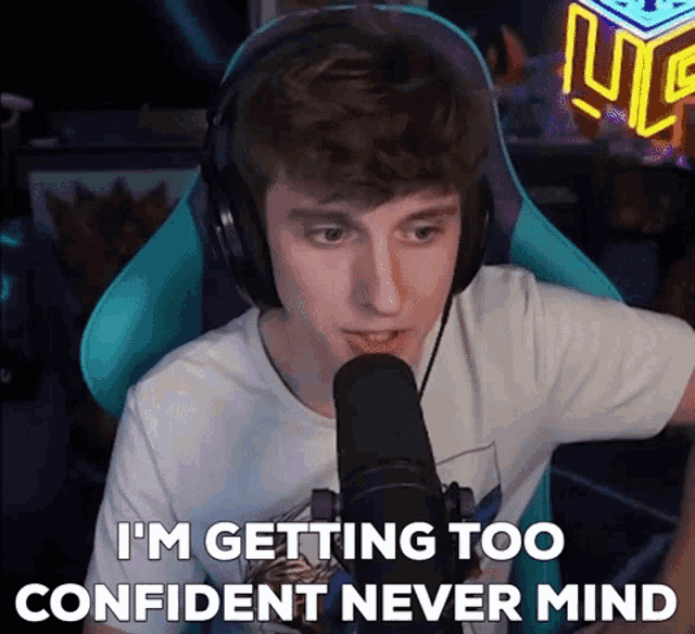 a man wearing headphones is talking into a microphone and saying i 'm getting too confident never mind