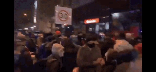 a large group of people are dancing in front of a sign that says 30 on it .
