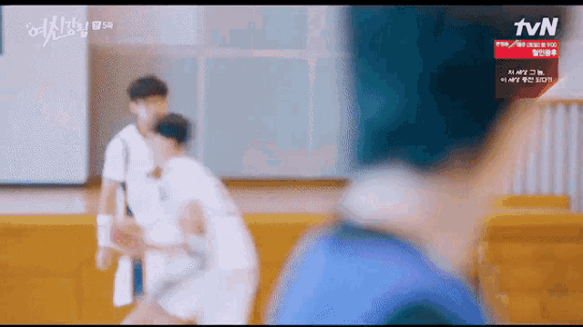a blurry picture of a person playing basketball with a tvn logo in the corner .