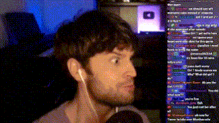 a man wearing ear buds talks into a microphone in front of a screen with a youtube logo