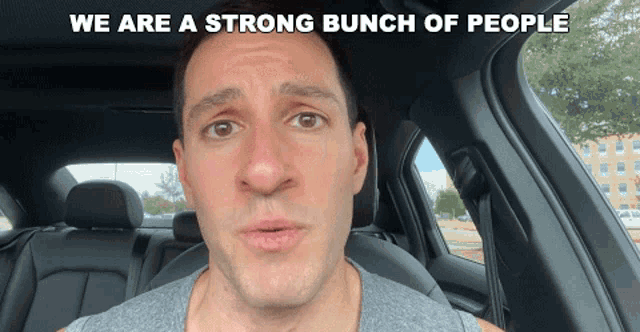 a man sitting in a car with the words we are a strong bunch of people above him