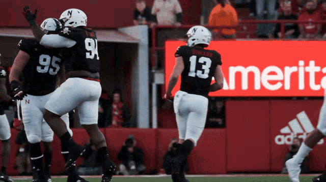 a football player in a black jersey with the number 13 on it