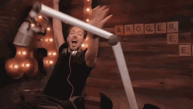 a man wearing headphones is sitting on a chair with his arms outstretched