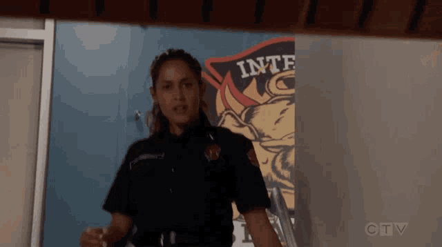 a woman in a police uniform is standing in front of a sign that says " inter "