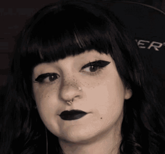 a close up of a woman 's face with the word er on her chair in the background