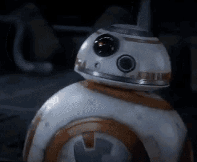 a close up of a bb-8 robot from star wars standing in a dark room .