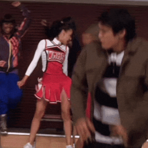 a cheerleader in a wmhs uniform is dancing with a man