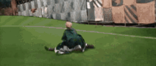 a bald man is laying in the grass with his head in the air .