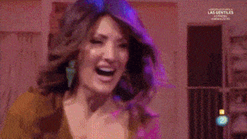 a woman is dancing on a stage in front of a purple chair with the number 2 on it