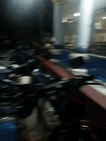 a blurred image of a room with a lot of tables and chairs