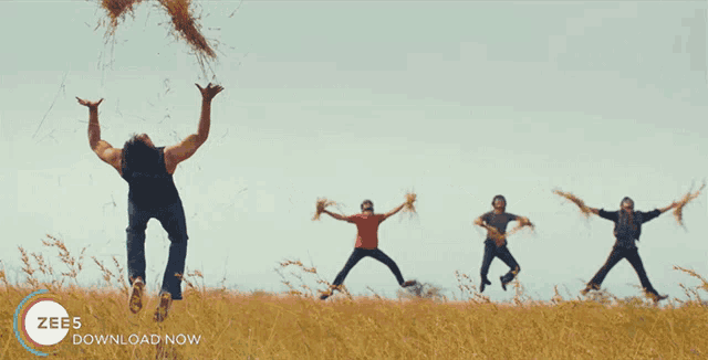 a group of people are jumping in a field with the words zee5 download now below them