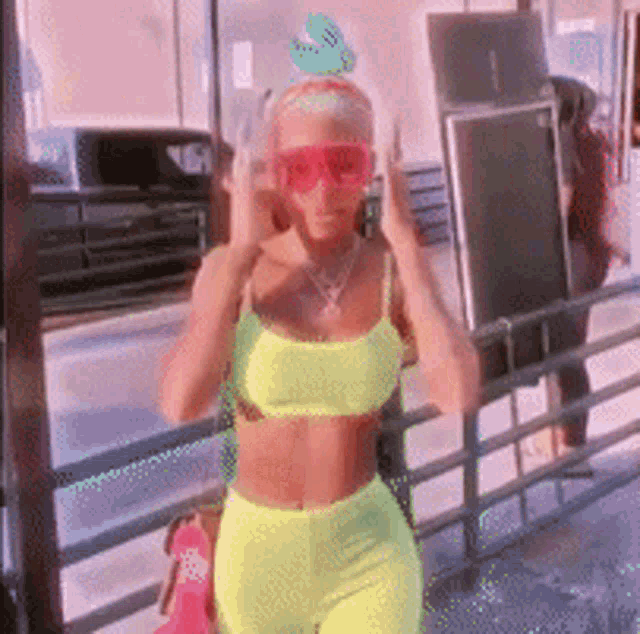 a woman wearing neon yellow clothes and red sunglasses