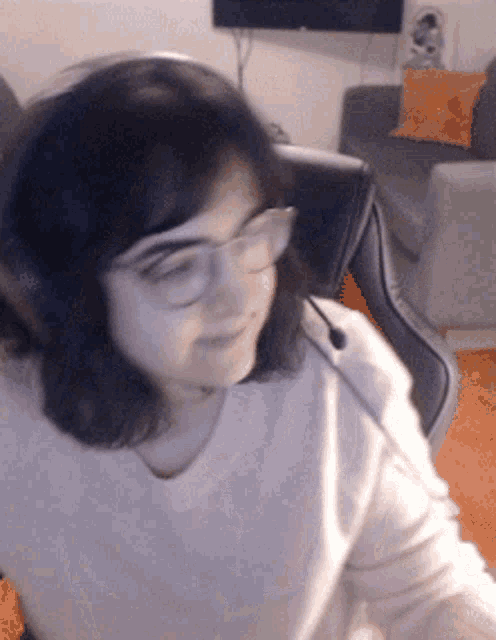 a woman wearing headphones and glasses is sitting in front of a television