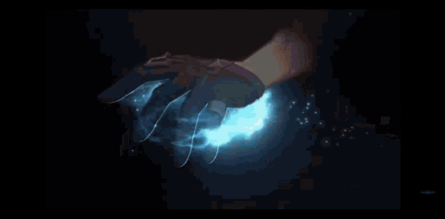 a person is holding a bat shaped object in their hand in a dark room .