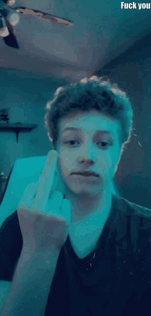 a young man giving the middle finger with the words fuck you behind him