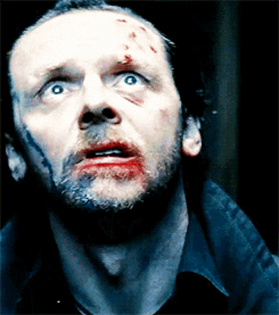 a man with blood on his face looks at the camera
