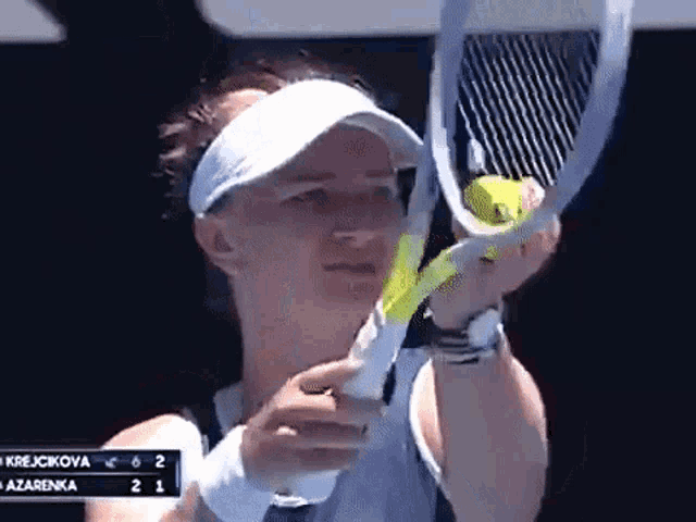 a woman is holding a tennis racquet in front of a scoreboard that says krejcikova 6 2 azarenka 2 1