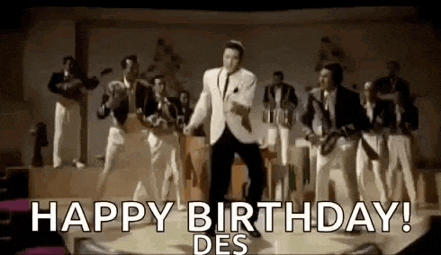 elvis presley is dancing on a stage in front of a band while singing happy birthday .